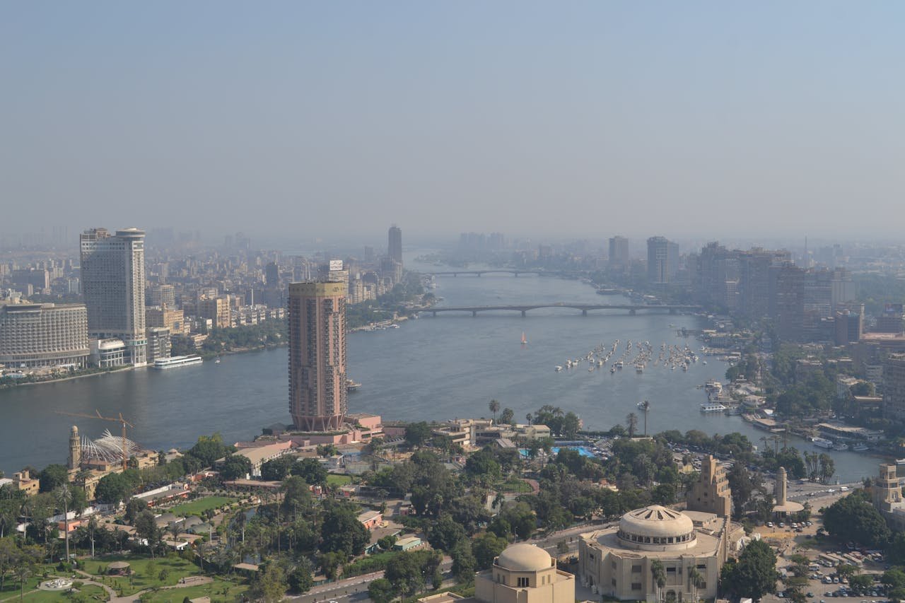 Aerial view of Cairo's skyline along the Nile River showcasing modern skyscrapers and historic architecture.